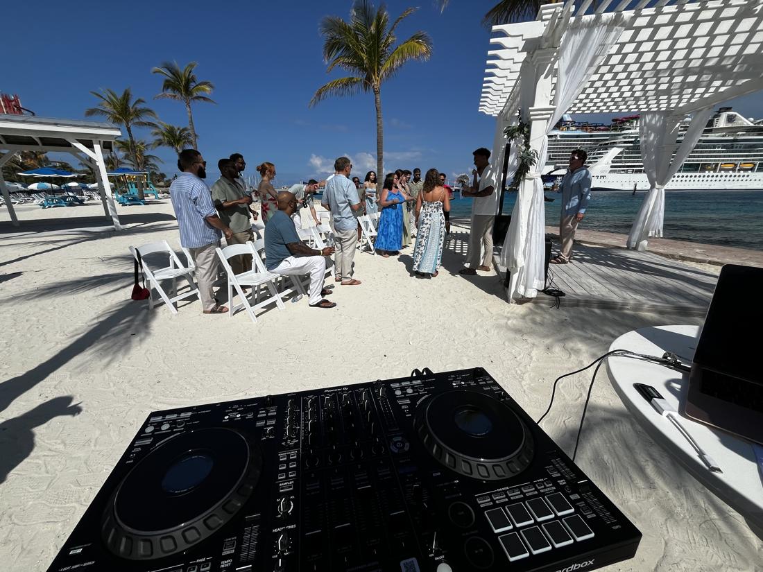 DJ setup at a beach wedding ceremony under a white pergola