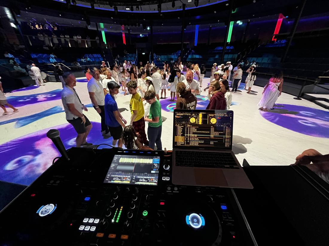 Teens and parents dancing on a lit-up floor at a white party
