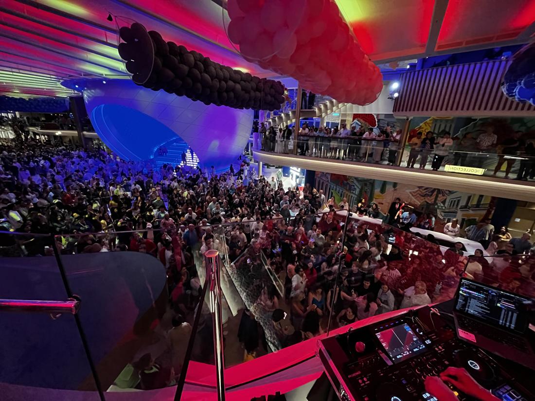 A packed room of hundreds of guests below the DJ booth