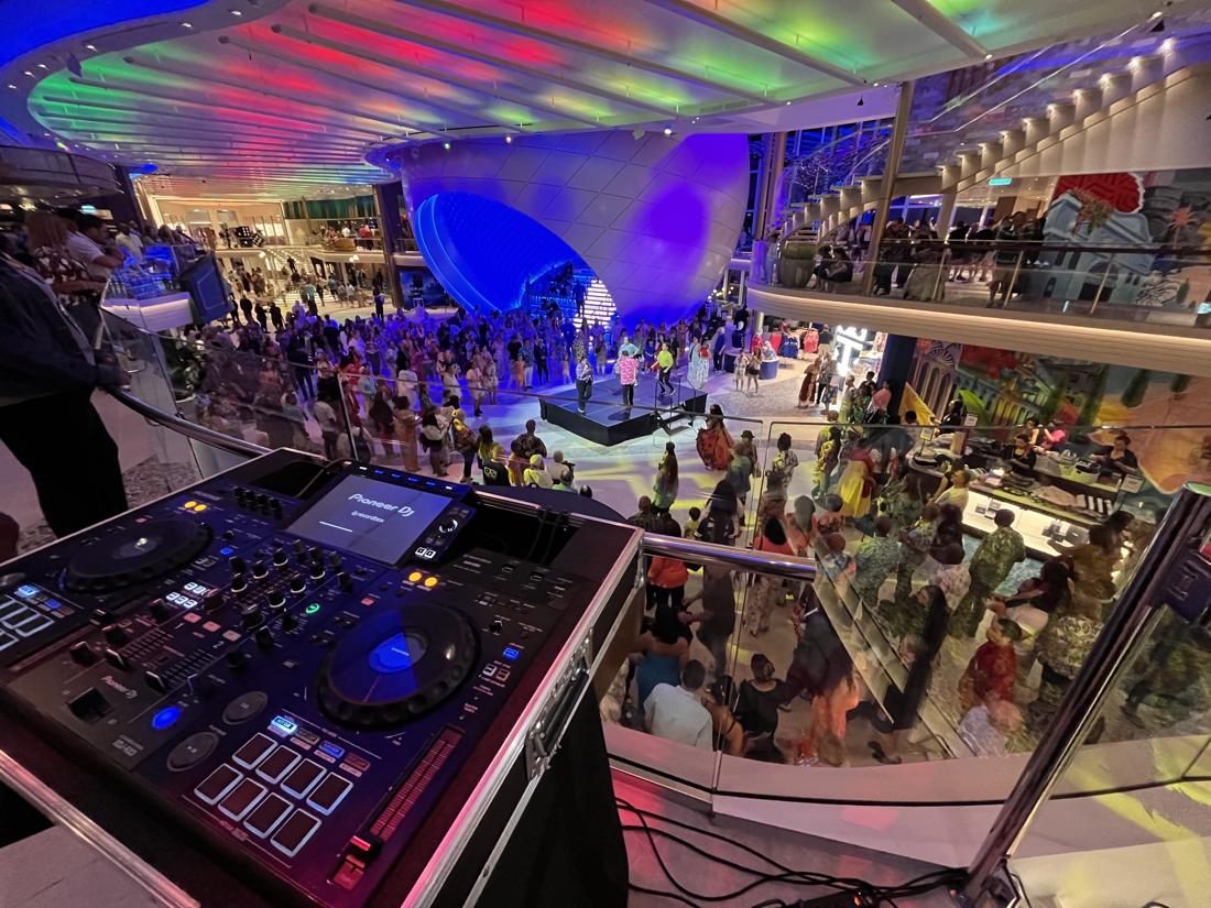 Crowd dancing under colourful ceiling lights